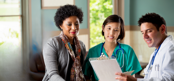 Doctor and nurse speaking to a patient of color