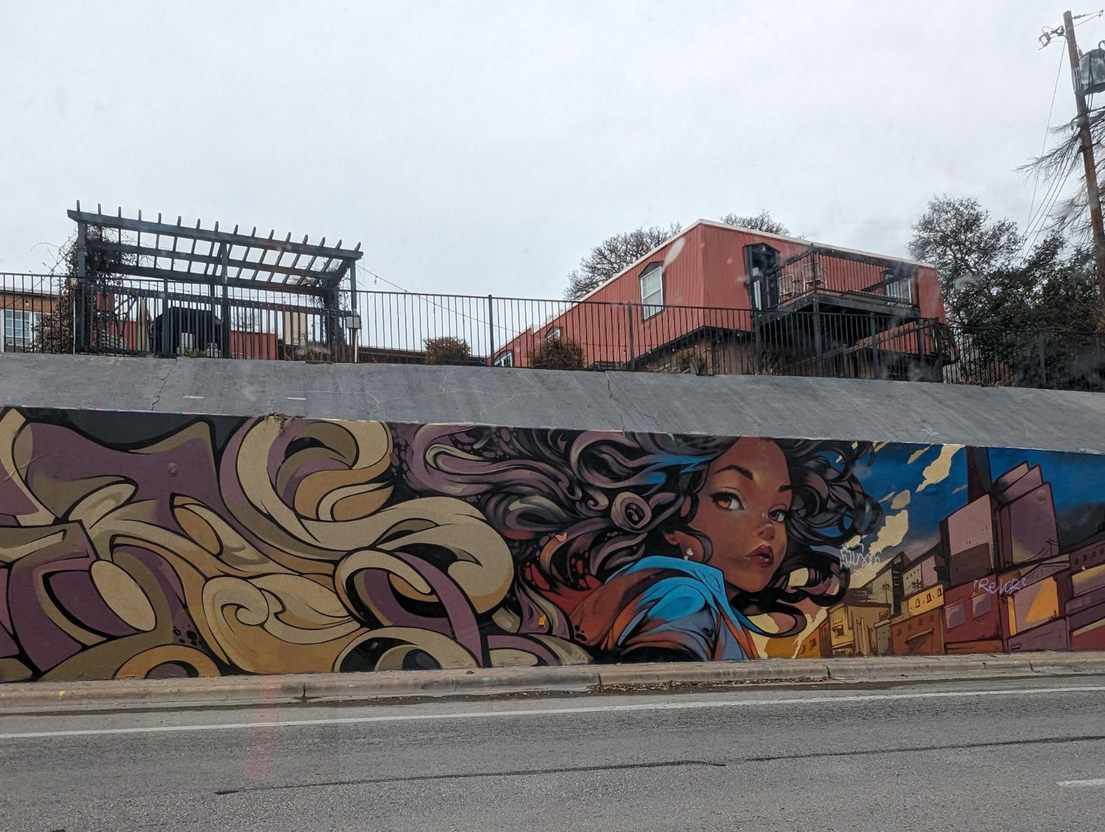 A photo of the "Chase The Light" mural before it was mended. The colors are dull, and graffiti has been drawn over some of the details.