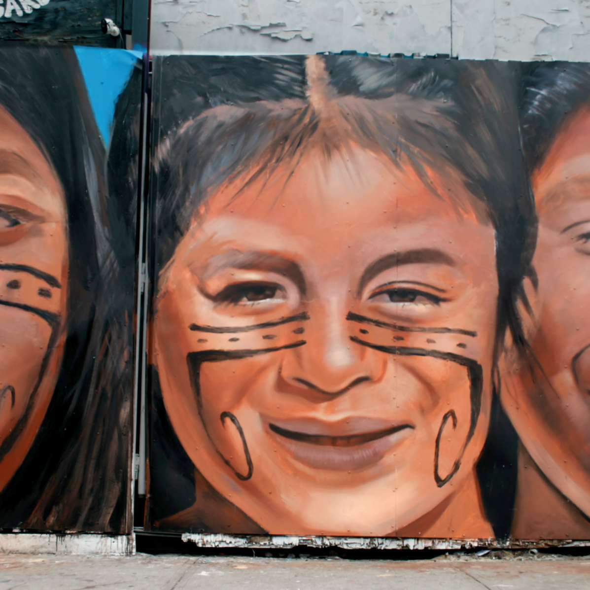 Part of the mural "Flowers Of The Empire." One Indigenous woman with facial markings looks directly at the viewer.